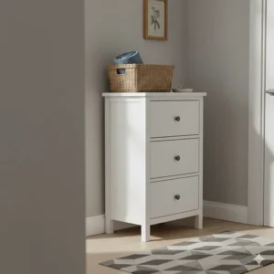 A compact white narrow chest of drawers used for hallway storage with a wicker basket on top.