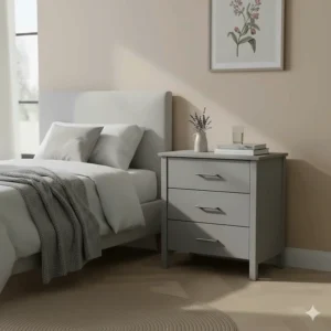 A compact grey small chest of drawers used as a bedside table in a guest room.