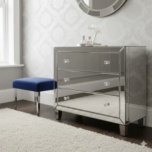 A luxurious bedroom interior featuring a Venetian-style mirrored chest of drawers with crystal handles.