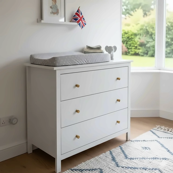 White wooden chest of drawers for a nursery styled with a changing mat and neutral decor. chest of drawers for nursery