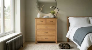 Minimalist Scandinavian style 5 drawer chest of drawers made from light oak with tapered legs and clean lines.