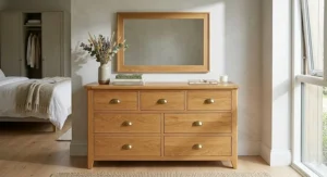 Modern white dresser and mirror set with a minimalist Scandinavian design, styled with soft grey decor items in a contemporary home.