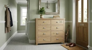 Lifestyle shot of a slim 8 drawer chest used as a storage solution in a narrow British hallway next to an umbrella stand.