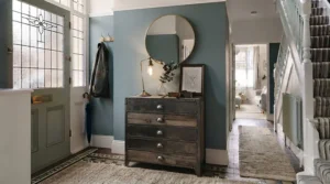 An industrial-style slim chest of drawers with metal legs in a rustic hallway setting.