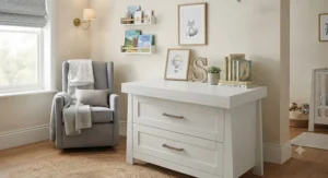 Modern white nursery dresser with changing top styled in a neutral baby room.