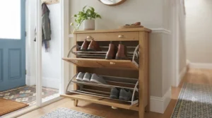 An open view of a multi-tier shoe rack integrated inside a wooden hallway drawer unit.