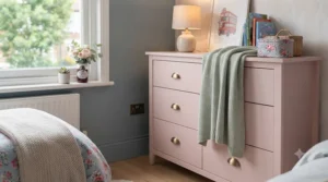Pink chest of drawers coordinated with matching bedding in a girls bedroom.