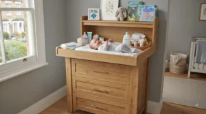 A classic oak-finish changing table chest of drawers adding warmth to a neutral-toned baby nursery.