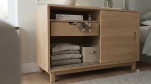 Close-up view of a smooth-gliding rail mechanism on a high-quality wooden sliding door chest of drawers.