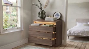 Side profile of a contemporary chest of drawers showing discreet touch-sensor controls for the built-in LED lighting.