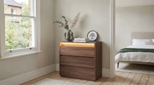 Traditional freestanding standard chest of drawers in a classic oak finish styled in a British bedroom.
