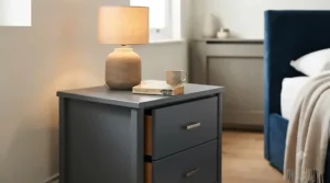 An alternative angle of the bedroom scene, focusing on the left-hand industrial bedside table, showing the full extent of the two rustic wood drawers and the metal frame, with the lamp and mug on top.