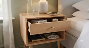 Close-up view of the smooth-glide drawer and open shelf on a slim bedside table, ideal for storing nighttime essentials.