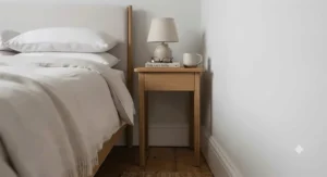 Technical dimension overlay of a slim bedside table showing a compact 25cm width, perfectly sized for tight gaps between a bed and wall.